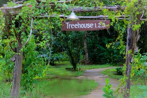 Una pérgola de madera con un cartel que dice 'Treehouse 1.2.3'.