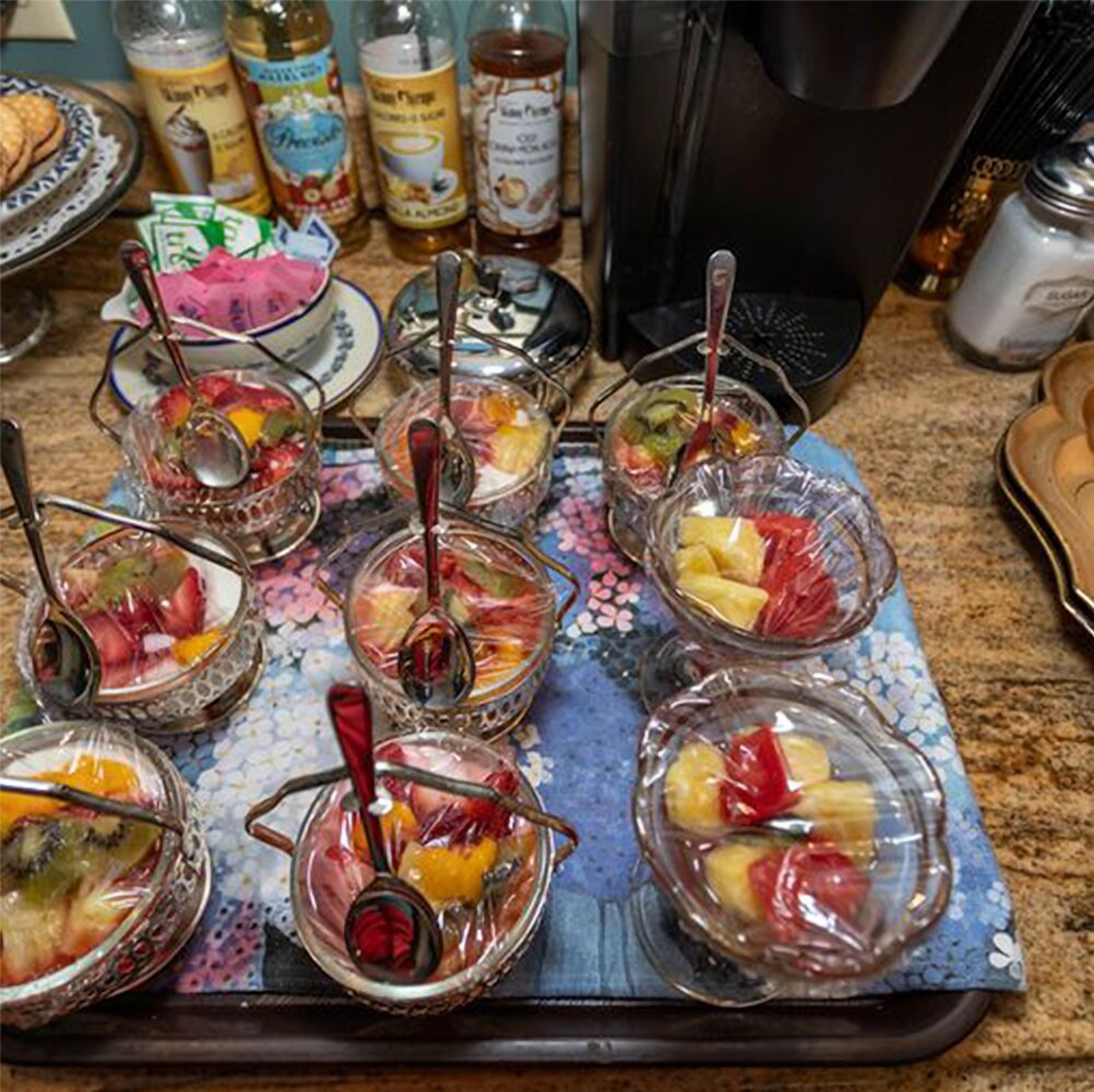 Una bandeja con diferentes cuencos de fruta y una máquina de café.
