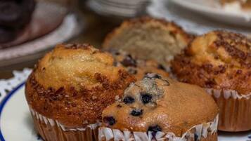 En tallerken med muffins med et blåt og hvidt mønster, placeret på et bord med et blondehvide.