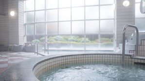 A hot tub area with a view of a garden through large windows. - Wisterian Life Club Verde no Mori (Hakone)