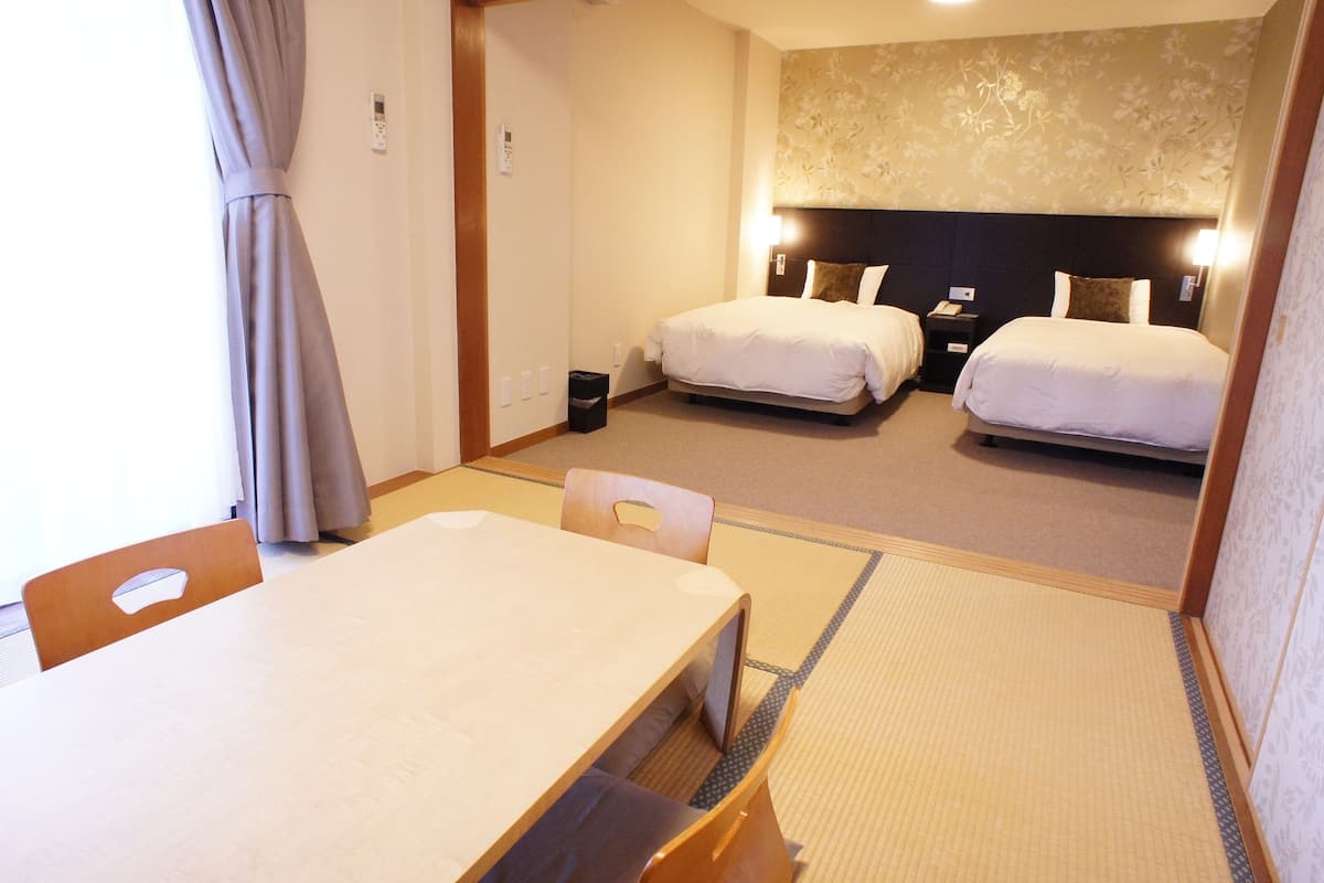 Une chambre d’hôtel avec un lit, une table de chevet, une chaise et une petite table.