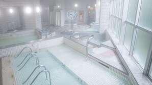 A public indoor swimming pool with multiple lanes, a clock, and a changing room area. - Wisterian Life Club Verde no Mori (Hakone)