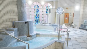 A spa area with a hot tub, stone steps, and a clock. - Wisterian Life Club Verde no Mori (Hakone)