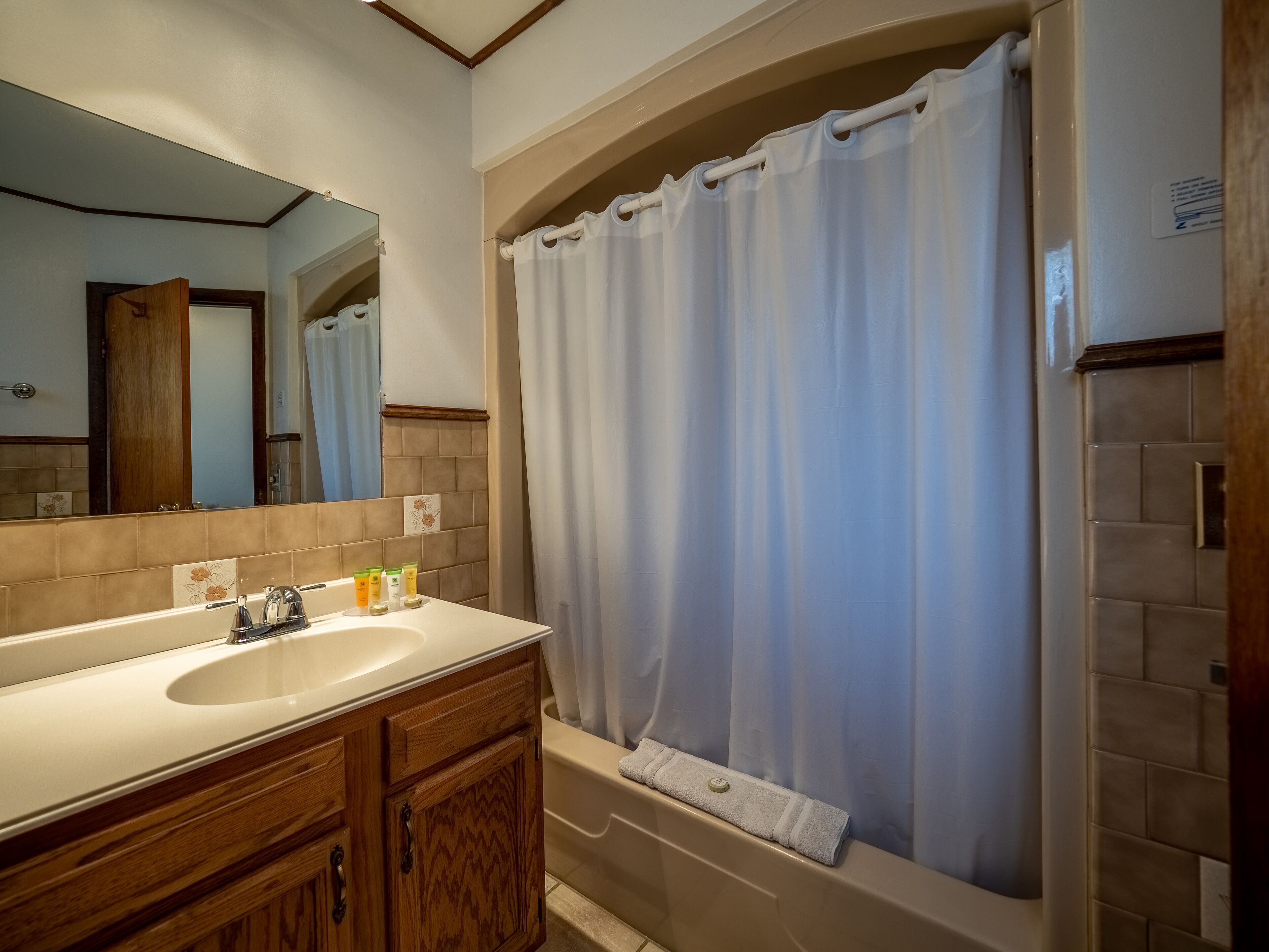 A bathroom with a bathtub, a sink, and a mirror.