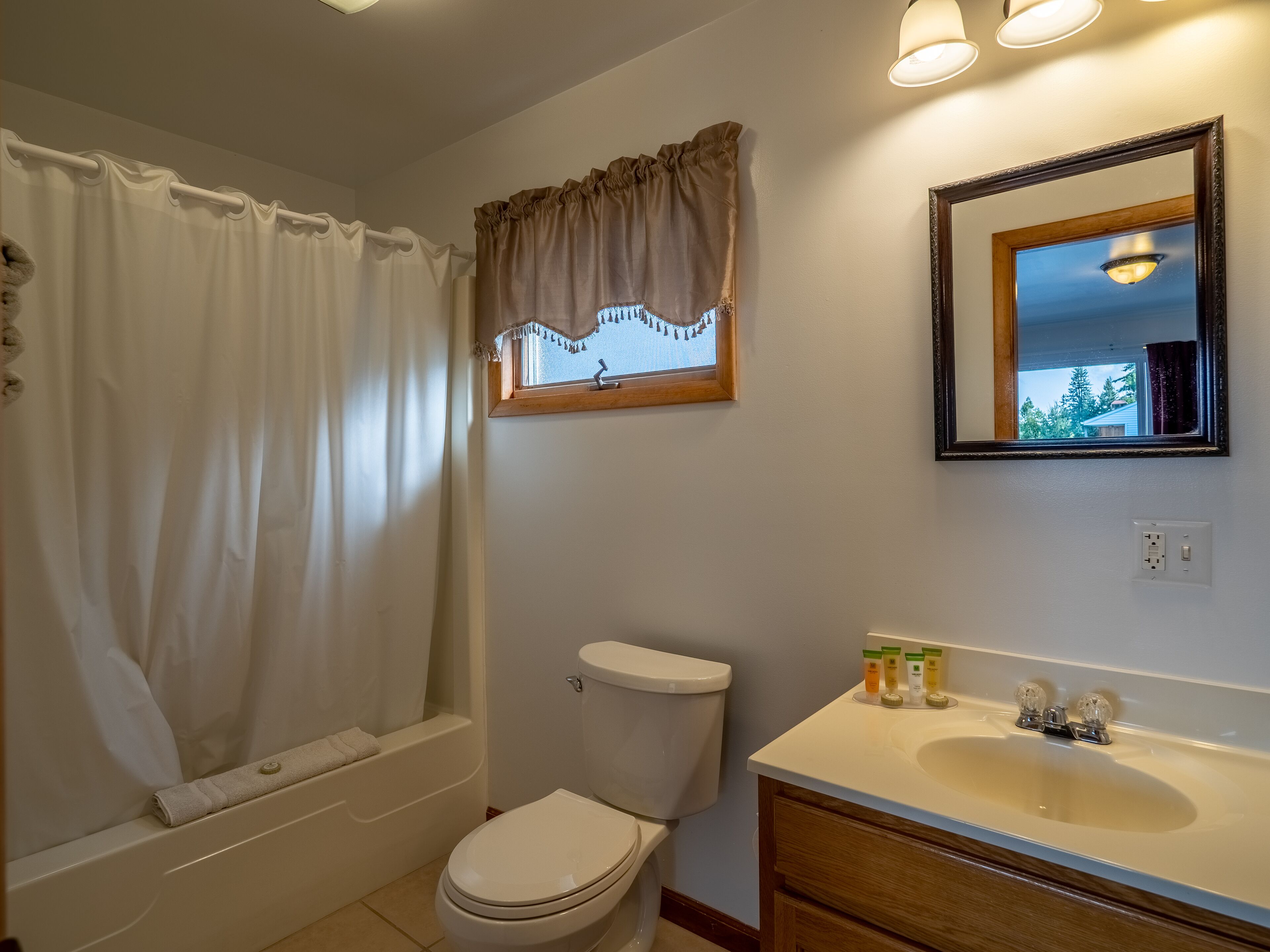 A bathroom with a bathtub, toilet, and sink.