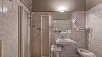 Un baño con ducha, lavabo y bidé.