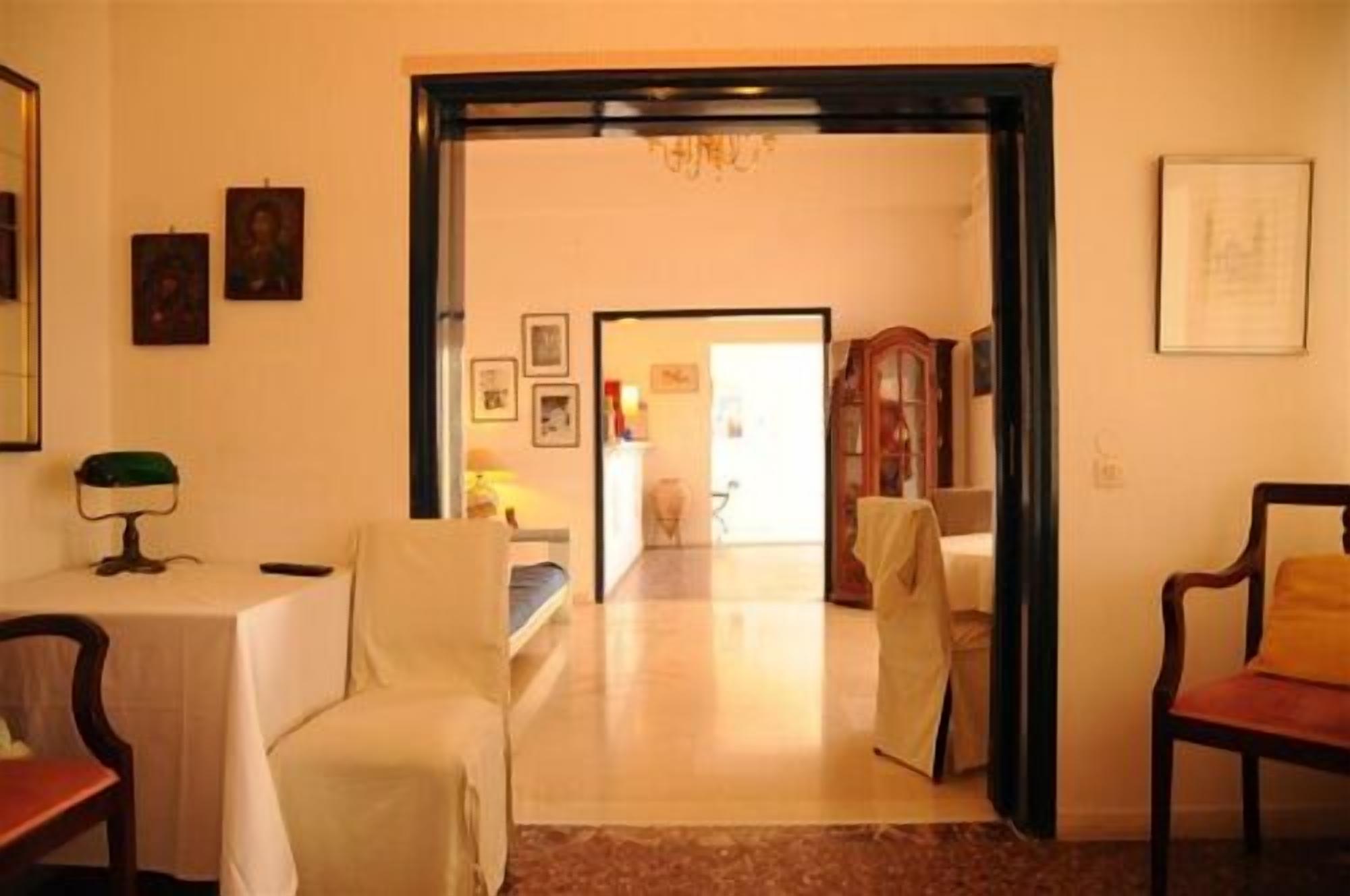 Una habitación con cama, escritorio y silla. Hay una puerta que da a otra habitación.
