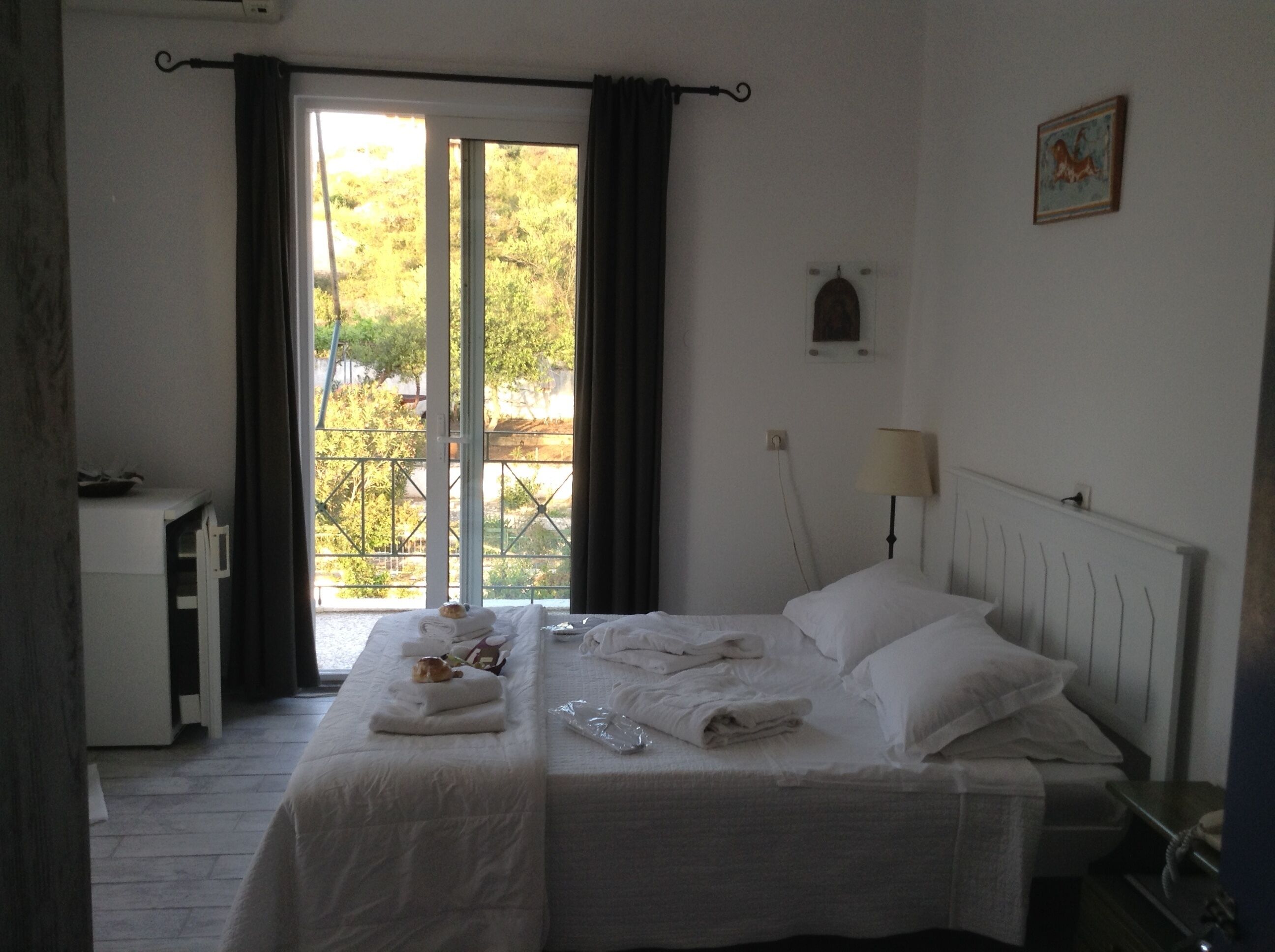Habitación de hotel con cama, escritorio, lámpara y vistas por la ventana.
