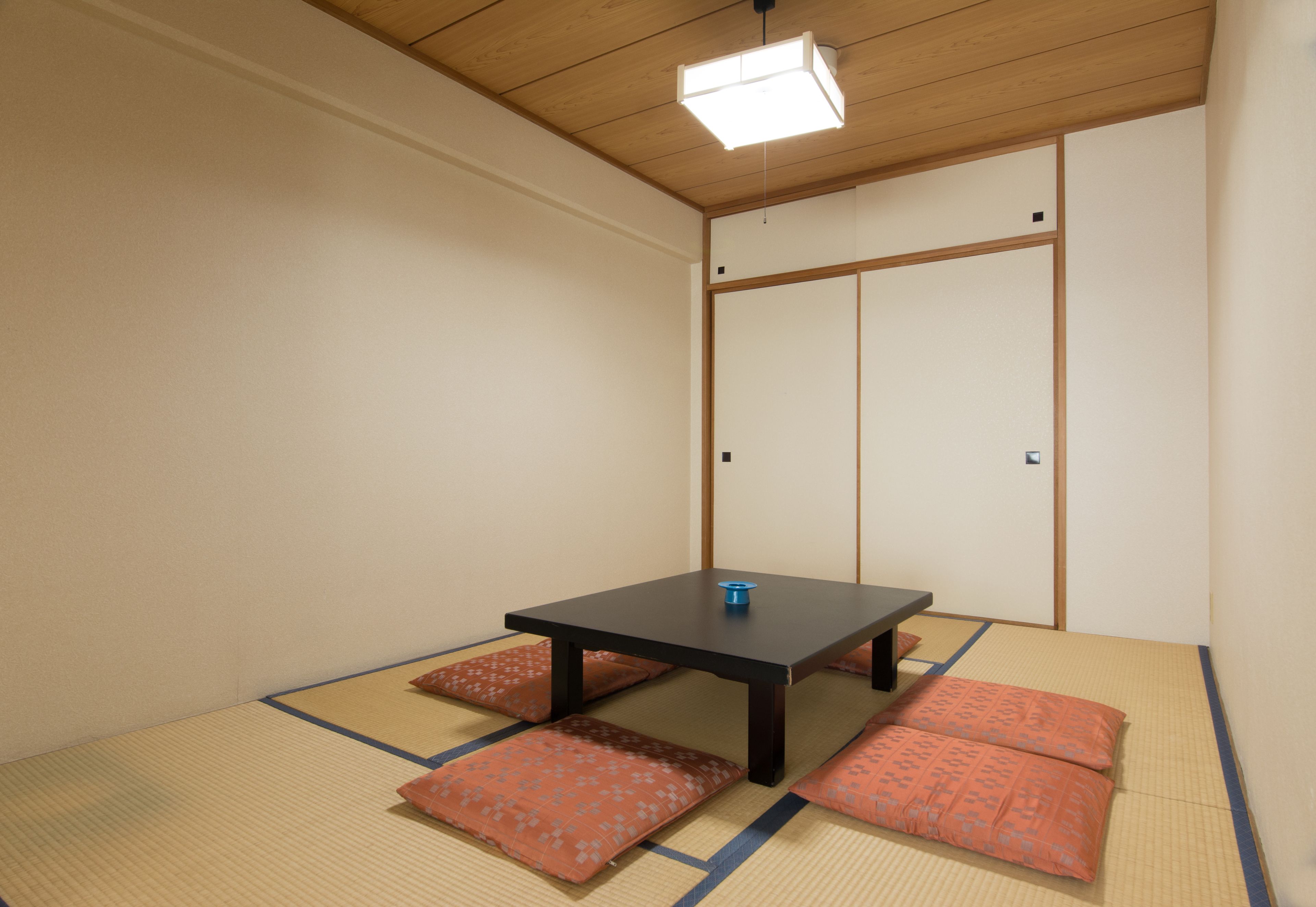 A tatami mat room with a low table and cushions.