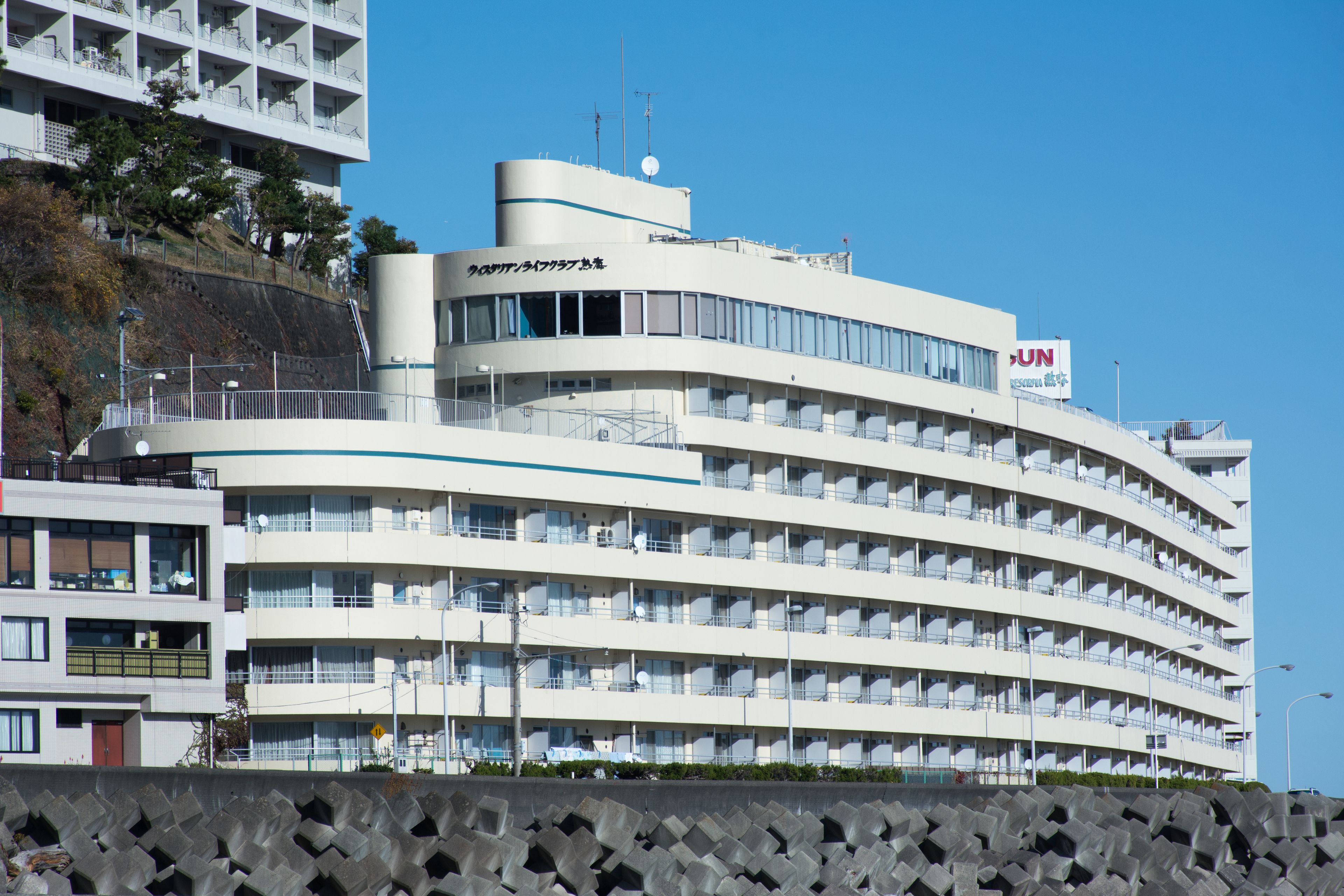A multi-story hotel with a curved facade, balconies, and a sign indicating it is a UN hotel.