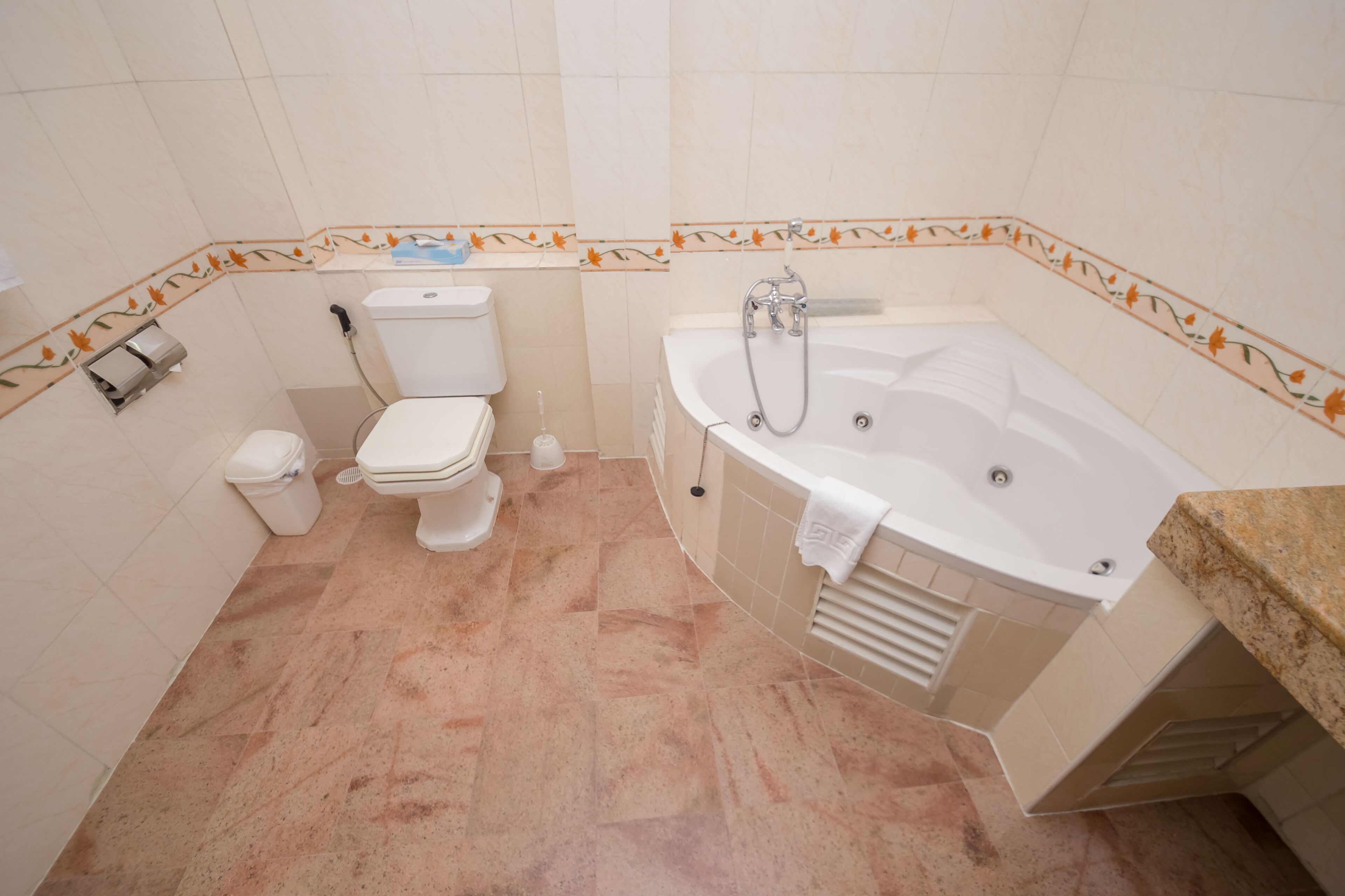 Een badkamer met een toilet, een bidet en een bad.