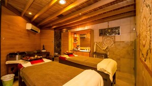 Ein Zimmer mit zwei Betten, einer kleinen Küchenzeile, einem Badezimmer und einer Wand mit Dekoration.