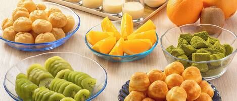 A variety of food items including pastries, fruits, and beverages arranged on a table.