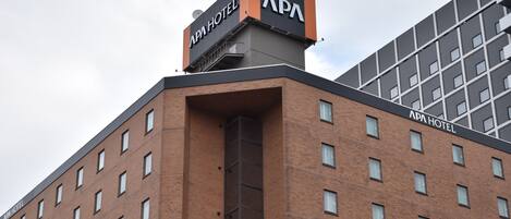 A hotel building with a prominent 'APA HOTEL' sign on the roof.