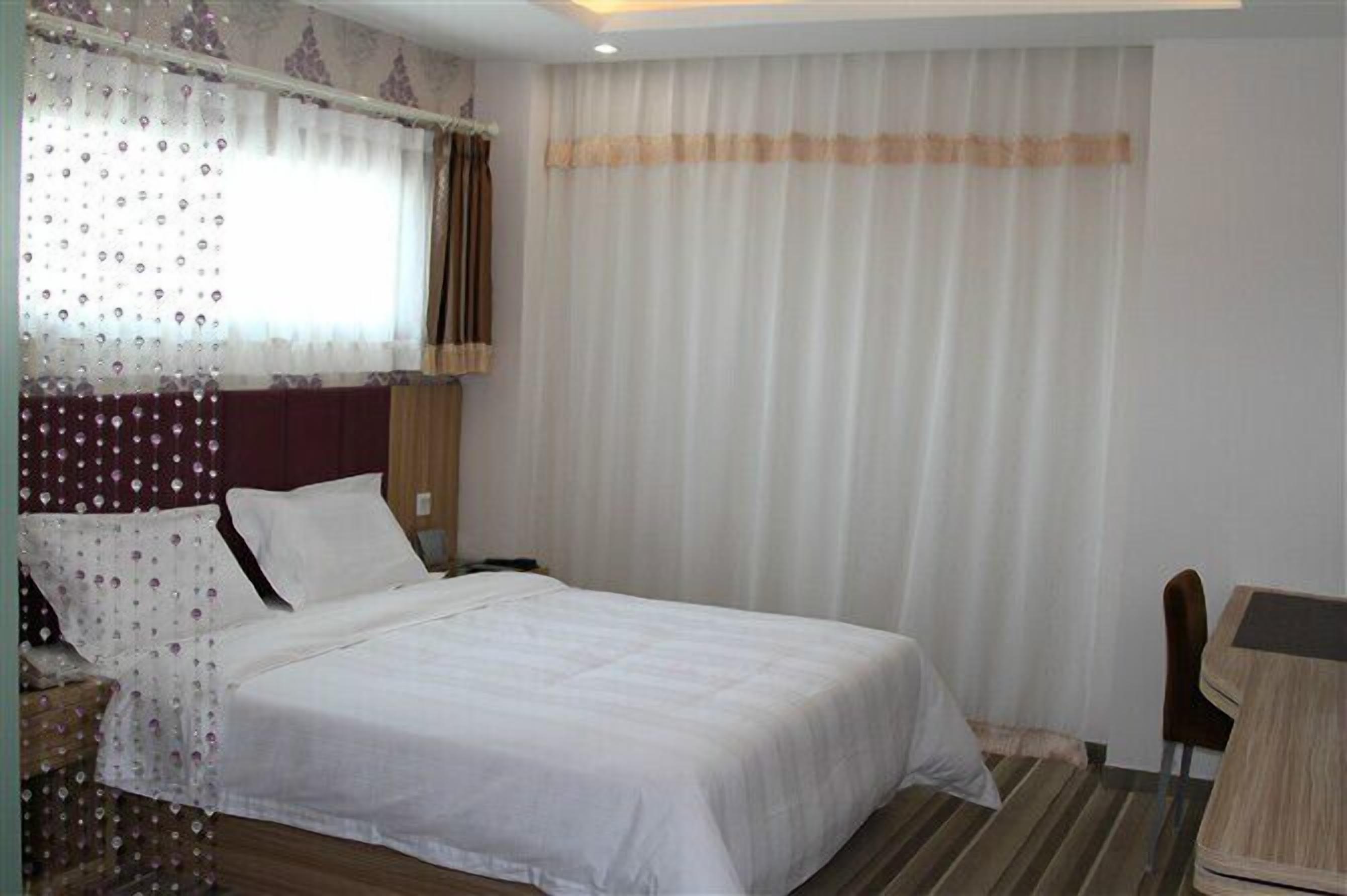 Una habitación de hotel con una cama, un escritorio y una silla.