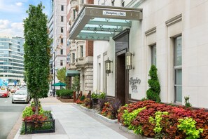 A Hampton Inn hotel with a classic facade, a covered entrance, and a well-maintained sidewalk with plants. - Hampton Inn Washington, D.C./White House (Washington)