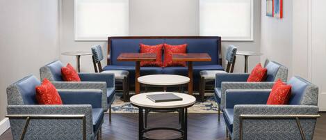 A modern lounge area with a sofa, two armchairs, a small table, and a coffee table.