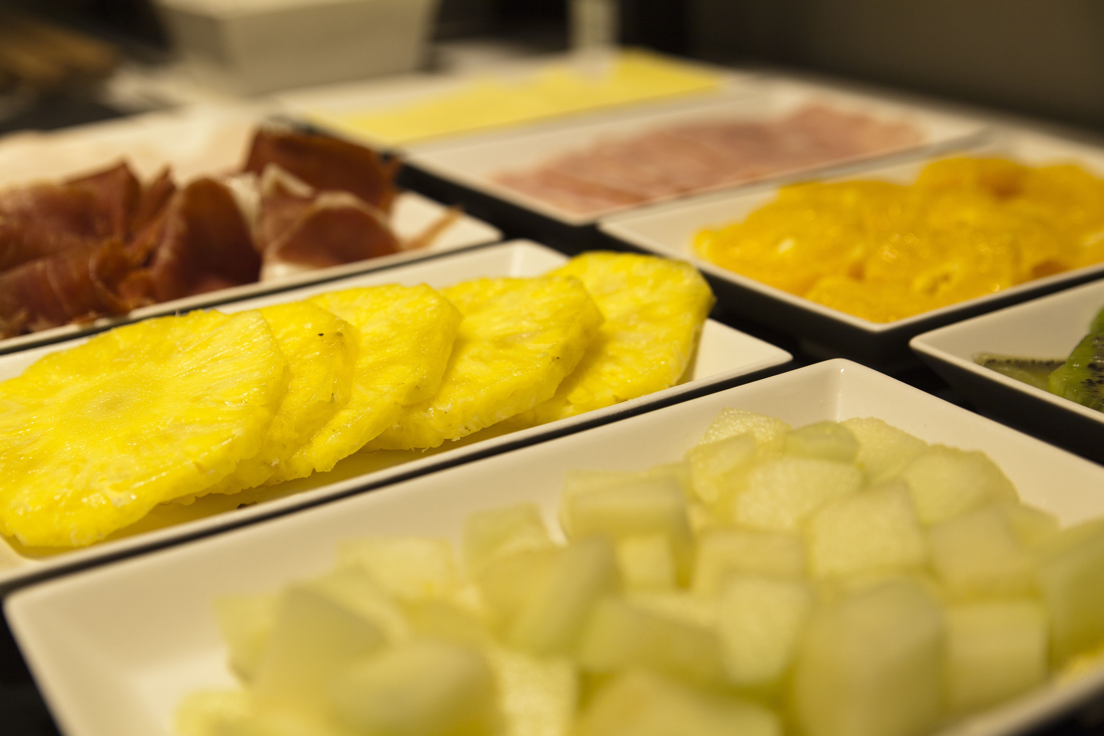 A buffet with various food items including pineapple slices and other fruits.