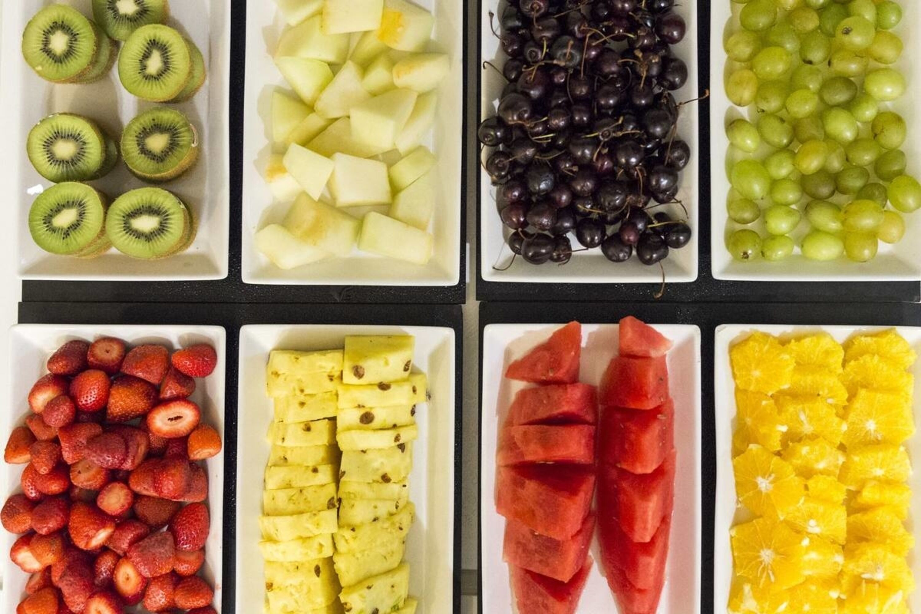 Diverse varietà di frutta disposte in scomparti separati.