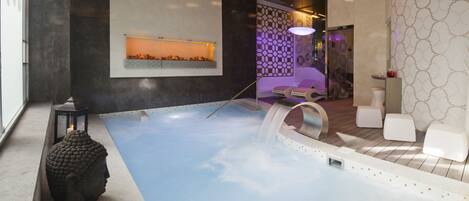 Un spa moderno con hidromasaje, zona de estar y elementos decorativos.