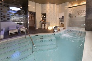 Un área de spa con un jacuzzi, zona de estar y mostrador de recepción.