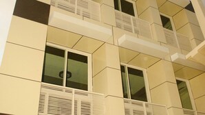 A multi-story building with a modern architectural design, featuring balconies and large windows. - Palawan Palm Suites (Puerto Princesa)