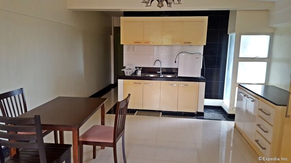 Una cocina compacta con comedor, que incluye un lavamanos, armarios y una encimera.