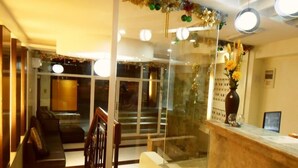 A hotel lobby with a reception desk, a staircase, and a seating area. - Palawan Palm Suites (Puerto Princesa)