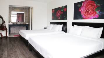 Habitación de hotel con dos camas, un espejo grande y un baño con baldosas estampadas.