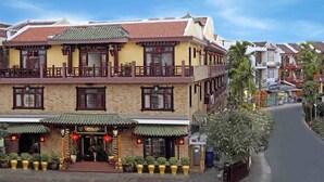 A two-story building with a traditional architectural style, featuring a balcony on the upper floor and a ground-level entrance with potted plants and red lanterns. - Thanh Binh II (Da Nang)