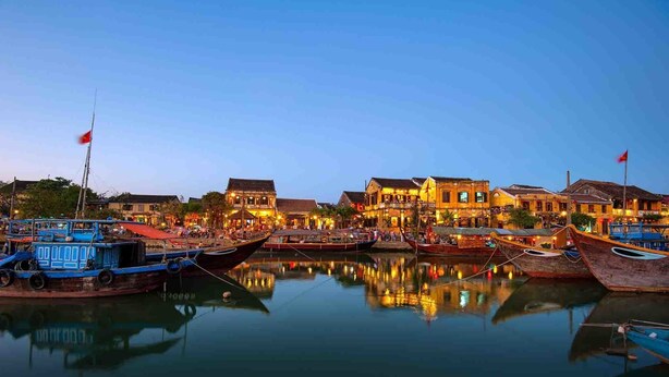 A waterfront area with traditional buildings and boats docked along the water. - Thanh Binh II (Da Nang)