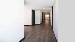 A modern hallway with wooden flooring and white walls. - Thanh Binh II (Da Nang)