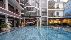 A multi-level hotel with a central swimming pool, balconies, and indoor dining areas. - Thanh Binh II (Da Nang)