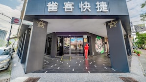 La entrada de un edificio con un letrero que dice '雀客快捷'.