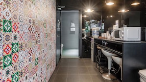 Una cocina moderna con un salpicadero decorativo, microondas y taburetes de bar.