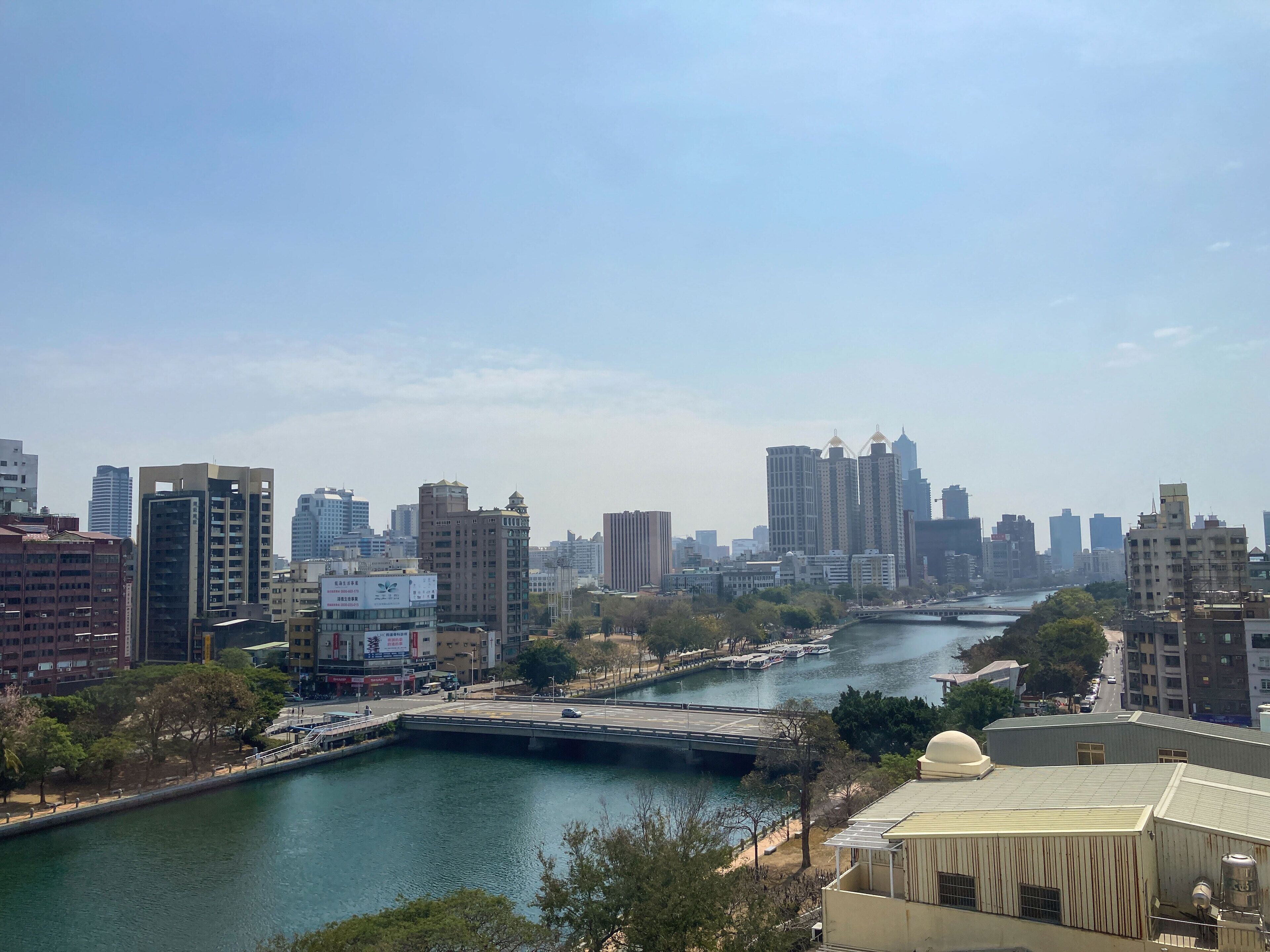 A cityscape with a river, high-rise buildings, and a bridge.