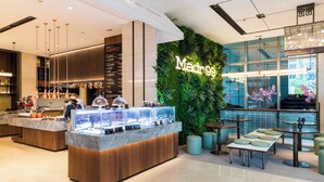 A modern cafe with a green wall and a menu display. - Pan Pacific Serviced Suites Ningbo (Ningbo)