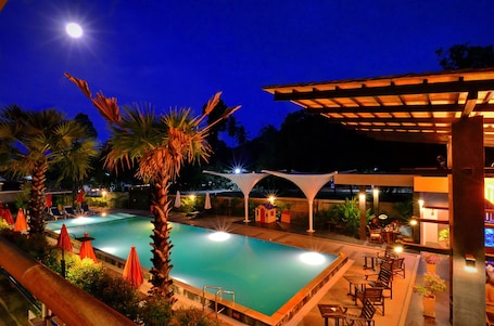 Una piscina al aire libre, sombrillas, sillones reclinables de piscina