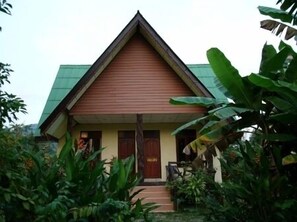 Et traditionelt hus med et stejlt tag, en veranda og en lille trappe op til indgangen.