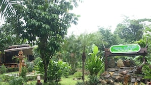 Un exuberante jardín con un cartel que indica 'Khao Yai National Park'.