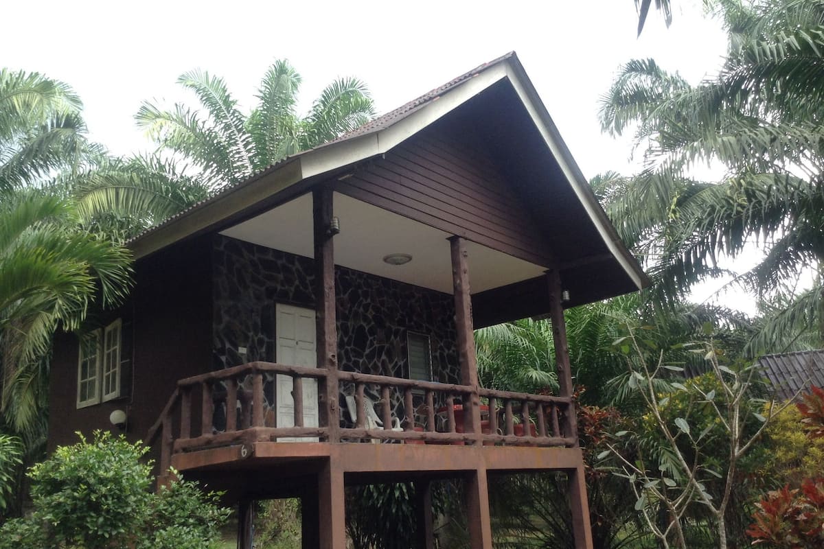 A two-story house with a wooden balcony and a stone facade.