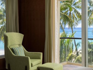 A room with a large window offering a view of palm trees and the ocean. - Mövenpick Resort & Spa Boracay (Boracay Island)