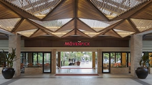 A modern building entrance with a wooden ceiling and a sign reading "MÖVENPICK". - Mövenpick Resort & Spa Boracay (Boracay Island)