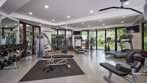 A modern gym with various exercise equipment, large windows, and a clean, spacious layout. - Mövenpick Resort & Spa Boracay (Boracay Island)