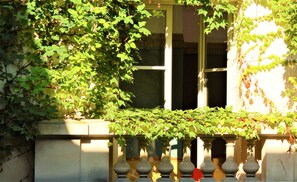 Fachada de edificio con ventana y barandilla.