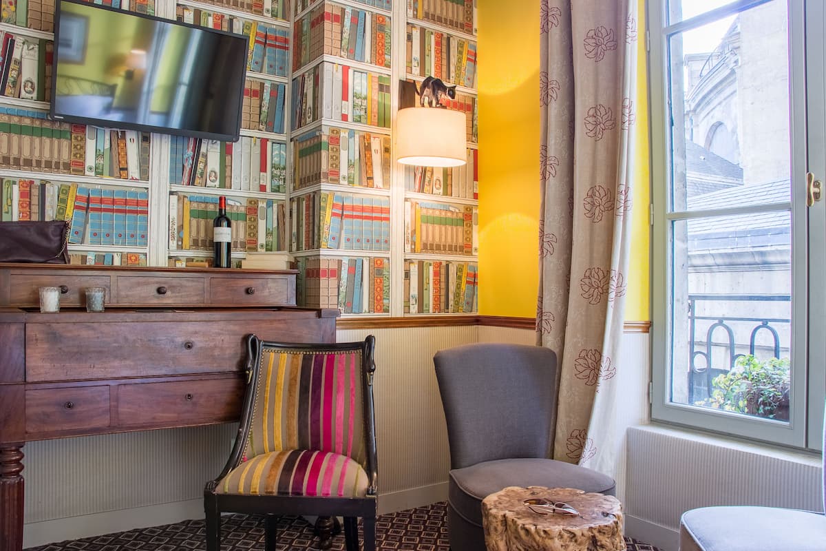 Un rincón acogedor para leer con una estantería, un sillón cómodo y una pequeña mesa.