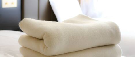 A neatly folded white blanket on a bed.