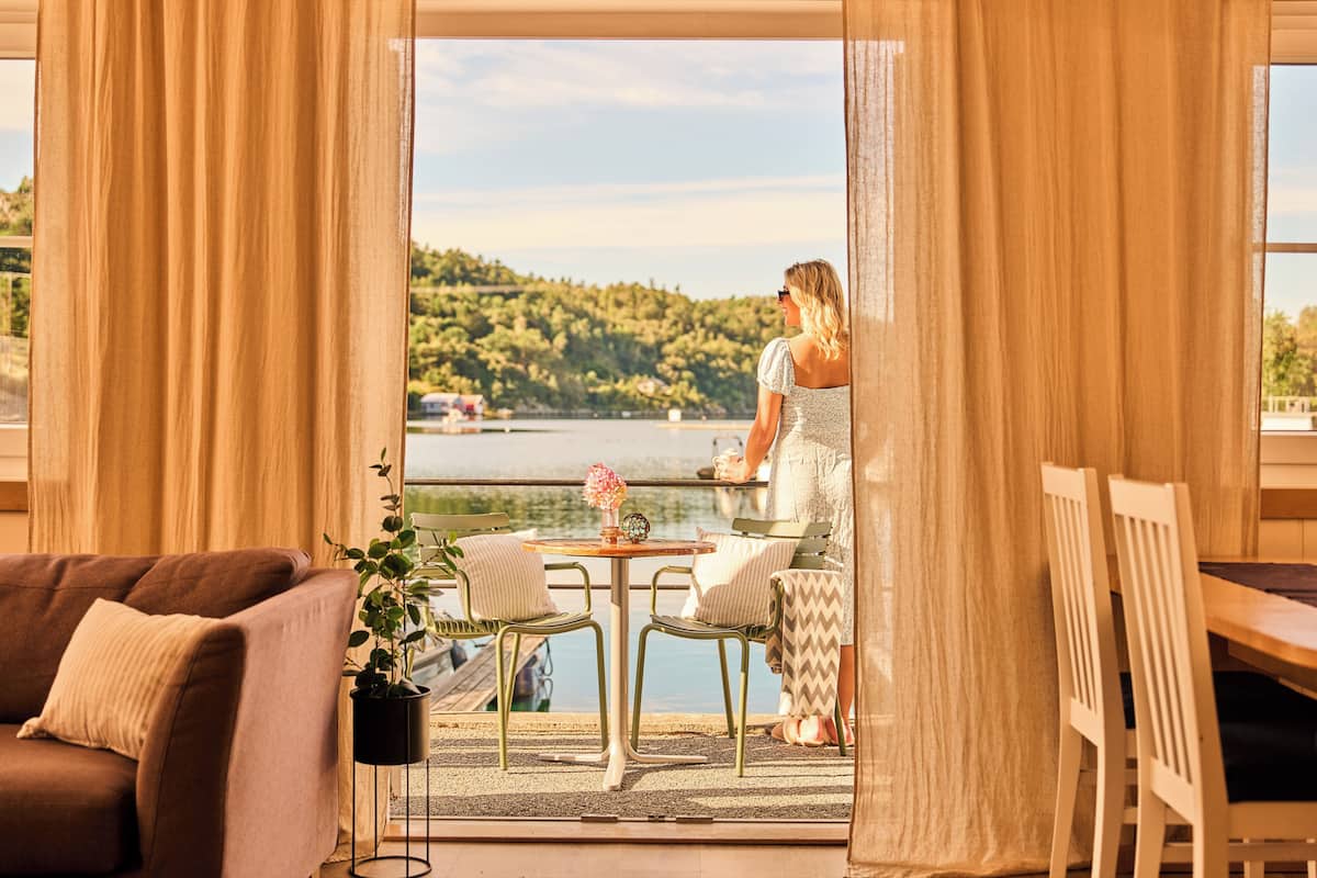 Une pièce avec vue sur un lac, une table à manger avec des chaises et un canapé.