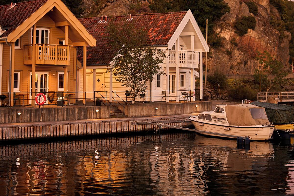 Une propriété située au bord de l’eau, dotée d’un quai, d’un bateau et d’une maison avec balcon.