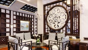 A traditional-style room with a wooden lattice partition, a round decorative window, and a round table with a vase of flowers. - Days Inn by Wyndham Patong Beach Phuket (Patong)